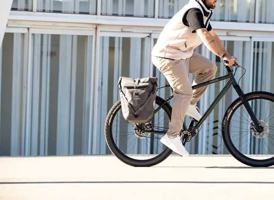 Ortlieb QL2.2 Fahrradtaschen - Person fährt auf einem Fahrrad, an dessen Hinterrad Ortlieb Taschen befestigt sind