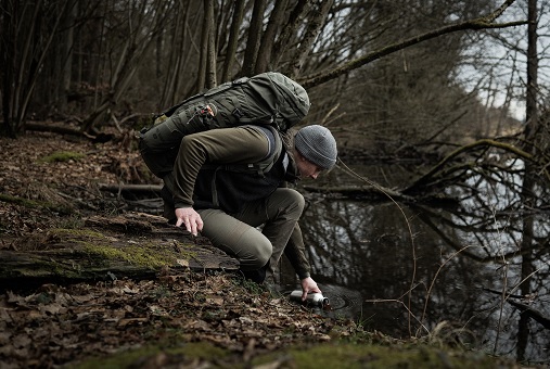 Person beim Bushcrafting mit Tatonka Rucksack