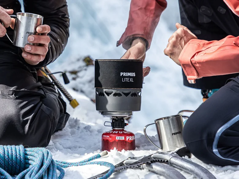 Outdoor Imagebild - Primus Outdoorkocher im Einsatz und wird mit einer Gaskartusche betrieben. Der Untergrund ist Schnee/Eis.
