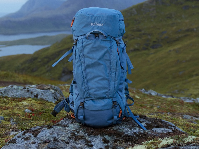 Tatonka Yukon Trekkingrucksack in blau steht in einer Landschaft auf einem Felsen