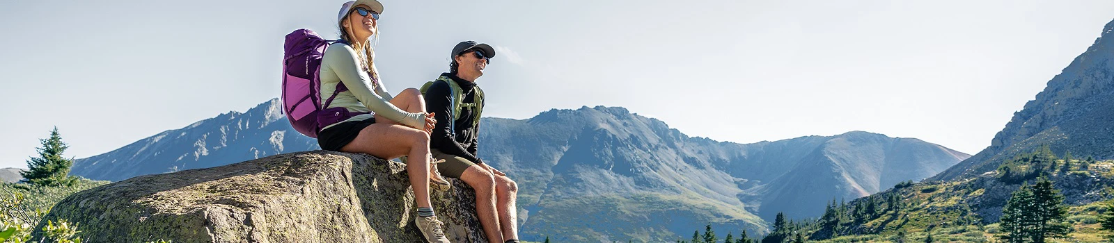 deuter Speed Lite Pro Rucksäcke in Aktion - zwei Personen mit deuter Rucksäcken sitzen im Gebirge auf einem Felsen