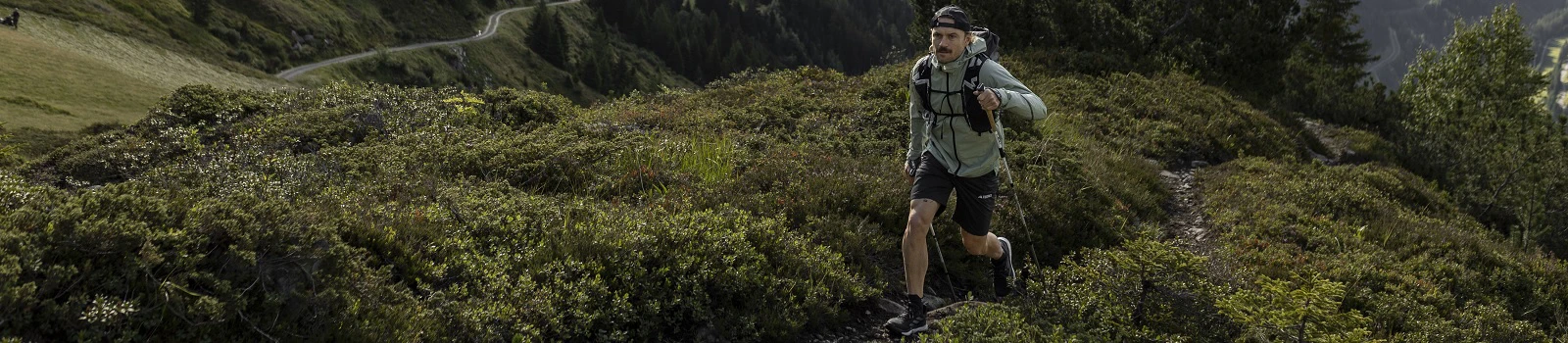 Outdoor Imagebild - Person mit Wanderstöcken bewegt sich in den Bergen fort