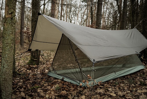 Bushcrafting Ausrüstung - Tarp ist im Wald aufgebaut