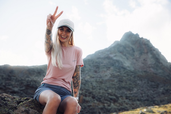 Viking Bambus Shirts - Person mit pinkem Shirt sitzt auf einem Fels im Gebirge