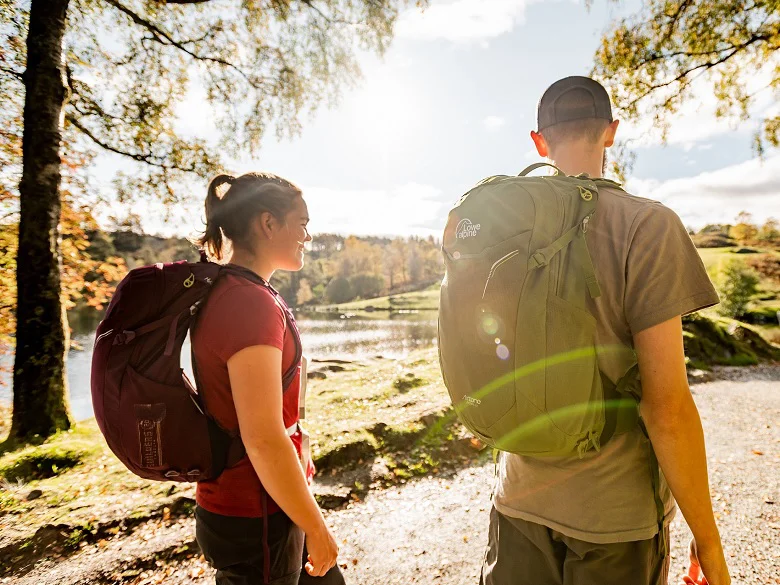 Outdoor Imagebild - zwei Personen mit Rucksäcken im freien. Der Sonnenstand ist niedrig.